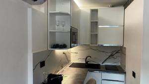 a kitchen with white cabinets and a sink at Pareti di mare in Capoliveri +54 photos