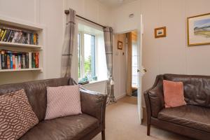 a living room with two leather couches and a window at Darroch Beag in Saint Catherines