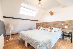 a bedroom with a bed and a brick wall at Gîte la Maison Rouge Béthune in Béthune