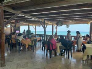 a group of people sitting at tables in a restaurant at Hotel Barbasquillo in Manta