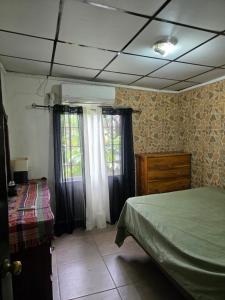 a bedroom with a bed and a dresser and window at La casa de Juana in Las Tablas +7 photos