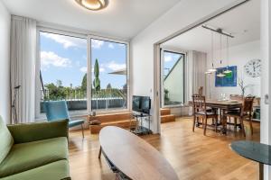 a living room with a couch and a table at Ferienwohnung Urlaubsglück- lichtdurchflutete Wohnung mit Balkon und Seesicht in Lindau