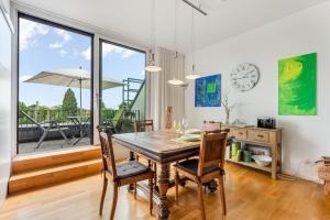 a dining room with a table and chairs and a large window at Ferienwohnung Urlaubsglück- lichtdurchflutete Wohnung mit Balkon und Seesicht in Lindau
