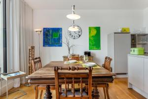 a kitchen and dining room with a wooden table and chairs at Ferienwohnung Urlaubsglück- lichtdurchflutete Wohnung mit Balkon und Seesicht in Lindau +12 photos