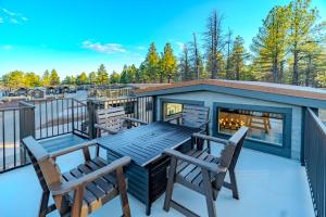 a deck with a table and chairs and a fireplace at Village Camp Flagstaff in Bellemont