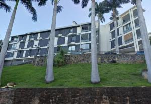 a large building with palm trees in front of it at Le Saphir in Saint-Denis