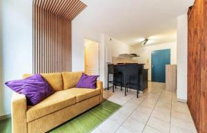 a living room with a couch and a kitchen at Le Saphir in Saint-Denis