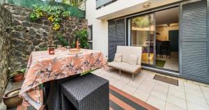 a table and a chair on a patio at Le Saphir in Saint-Denis +3 photos