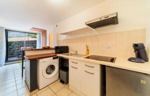 a kitchen with a sink and a washing machine at Le Saphir in Saint-Denis