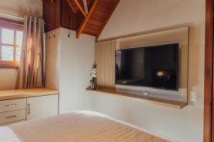 a bedroom with a large television on the wall at Cabanas Belo Destino in Gramado