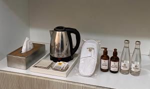 a counter with a coffee pot and bottles of wine at Fabulous Room in Muşaffaḩ