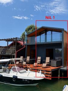 a small boat sitting in the water next to a house at NiL Cottage in Ulcinj +1 photo