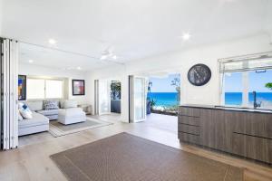 a living room with a view of the ocean at Ocean Panorama With Private Pool! in Noosa Heads