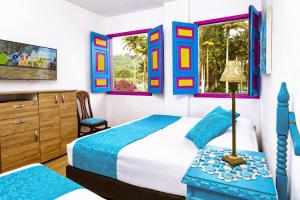 a bedroom with a bed and a dresser and two windows at La Posada de la Plaza in Salento +76 photos
