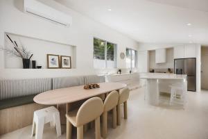 a kitchen with a table and some chairs and a counter at Coastal Haven on Witta in Noosa Heads