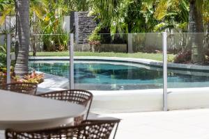 a table and chairs next to a swimming pool at Coastal Haven on Witta in Noosa Heads +25 photos