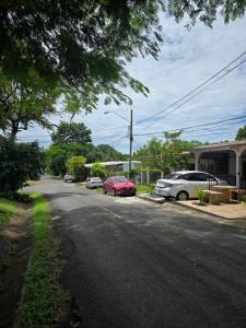 a street with cars parked on the side of the road at La casa de Juana in Las Tablas