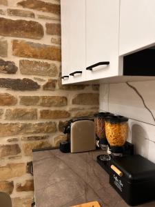 a kitchen with a counter with a stone wall at Civico 44 in Castelmezzano