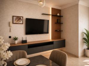 a living room with a television on a wall at Modern and Cozy in Agadir