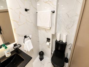 a bathroom with a black toilet and a sink at Modern and Cozy in Agadir +2 photos