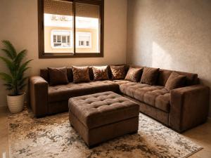 a living room with a brown couch and a window at Modern and Cozy in Agadir