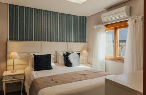 a bedroom with a large bed and a window at Cabanas Belo Destino in Gramado