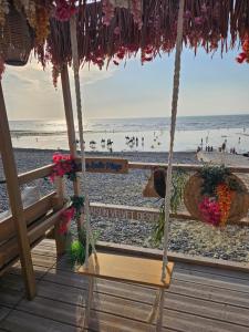a swing on a beach with a view of the ocean at Le coeur de Mers in Mers-les-Bains