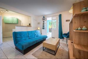 a living room with a blue couch and a table at 2-3 personnes - Vue Mer et Piscine - Anse à l Âne - trois Îlets - Plage 2 min en voiture in Les Trois-Îlets