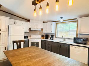 a kitchen with white cabinets and a wooden table at Put-in-Bay Island Club #71 in Put-in-Bay