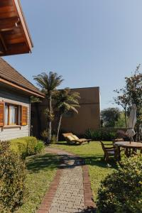 a garden with a bench and an umbrella and a table at Cabanas Belo Destino in Gramado