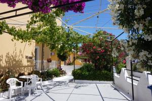 a patio with a table and chairs and flowers at Kapitan in Arillas +9 photos