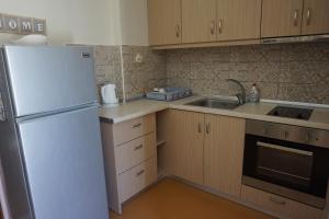a kitchen with a white refrigerator and a sink at Kapitan in Arillas