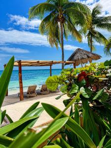 a beach with two chairs and a umbrella and the ocean at Caribbean apartment in Cancún