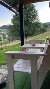 a white picnic table sitting under an umbrella at Карпатські Мандри in Verkhovyna