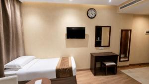 a hotel room with a bed and a clock on the wall at فندق الأرضُ المتميزه - Land Prime -1 in Mecca