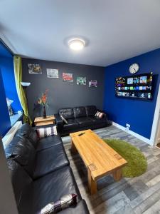 a living room with a black couch and a wooden table at The Blue Door 2 bedroom apartment in Perth