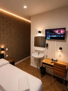 a bedroom with a bed and a sink and a tv at Hotel Holland Lodge in Utrecht