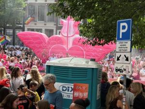 a crowd of people standing around in a pink parade at Mozart Hotel in Amsterdam