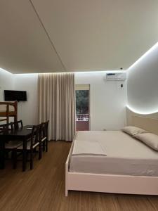 a bedroom with a bed and a dining room at Hotel Otrant in Velipojë +53 photos