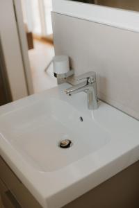 a white bathroom sink with a faucet on it at Natururlaub by Klotz TINY HAUS b in Überlingen