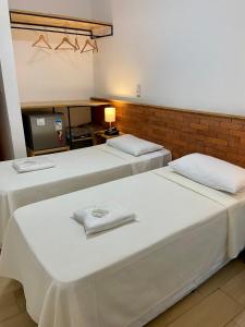 two beds sitting in a room with a room with at Requinte Hotel in São Paulo