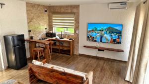 a living room with a couch and a tv on a wall at Modern Studio with Swimming Pool in Njiro, Arusha in Arusha