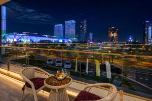 a balcony with a table and chairs and a city skyline at 7 Star Apartments in Tashkent