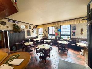 a restaurant with tables and chairs in a room at Hotel Bauernstube in Oberhausen