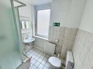 a bathroom with a toilet and a sink at Hotel Bauernstube in Oberhausen