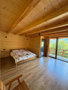 a bedroom with a bed in a wooden cabin at Rosi peak Guesthouse in Valbonë