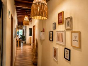 a hallway with pictures on the wall and a chandelier at Luum Guest House Manila in Medellín