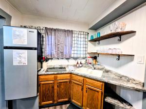 a kitchen with a sink and a refrigerator at Edgewater Resort Cottage #1 in Hot Springs