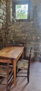 a wooden table with two chairs and a window at Tuscany House Retreat in Casentino in Subbiano