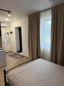 a bedroom with a bed and a large window at Central House in Cahul